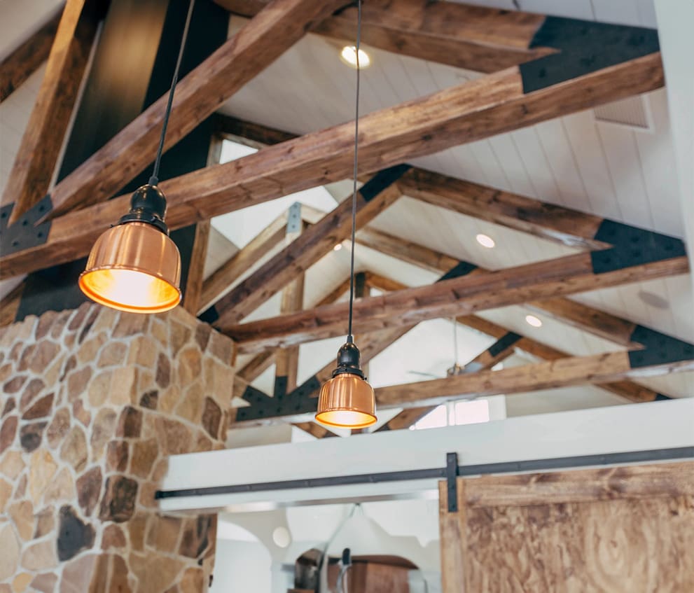 A room with wooden beams and lights hanging from the ceiling.