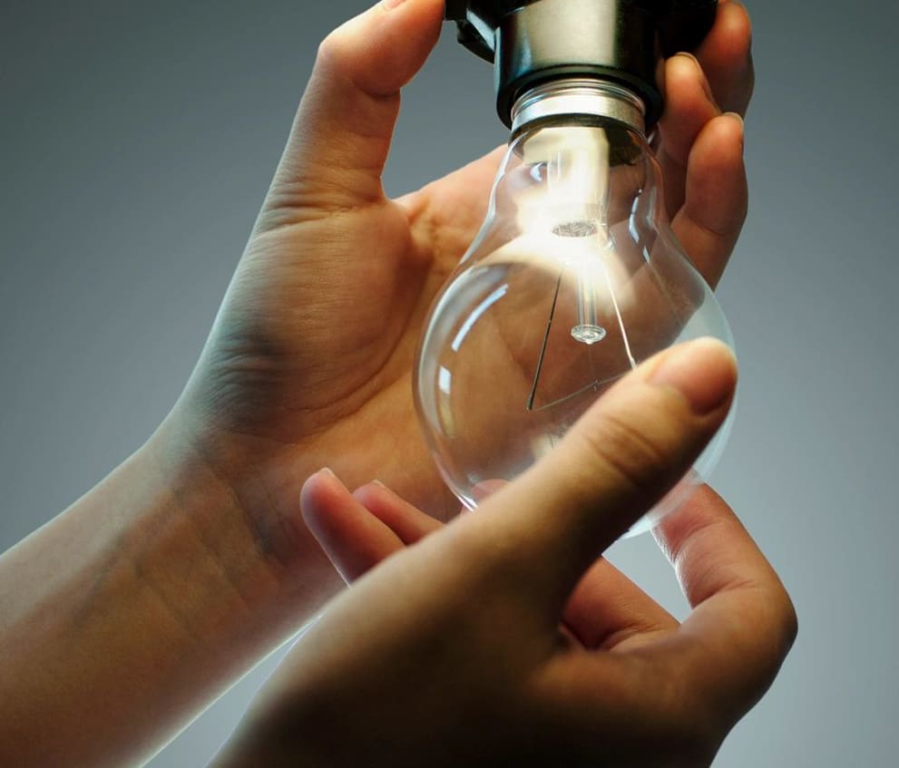 A person holding an electric light in their hands.