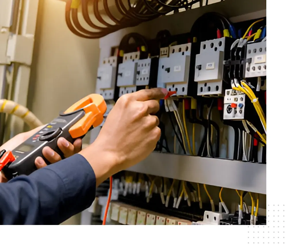 A person is working on electrical equipment