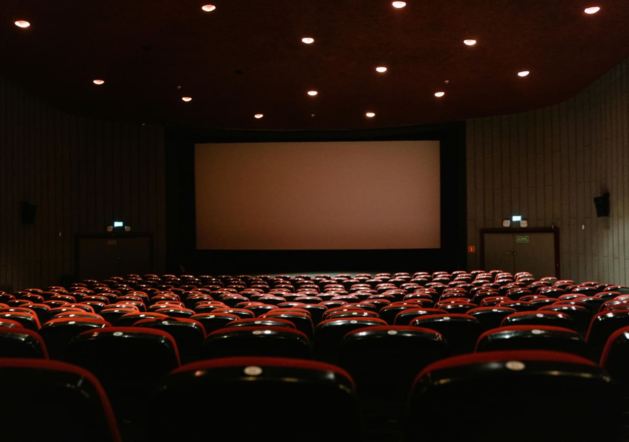 A large auditorium with rows of seats and a projector screen.